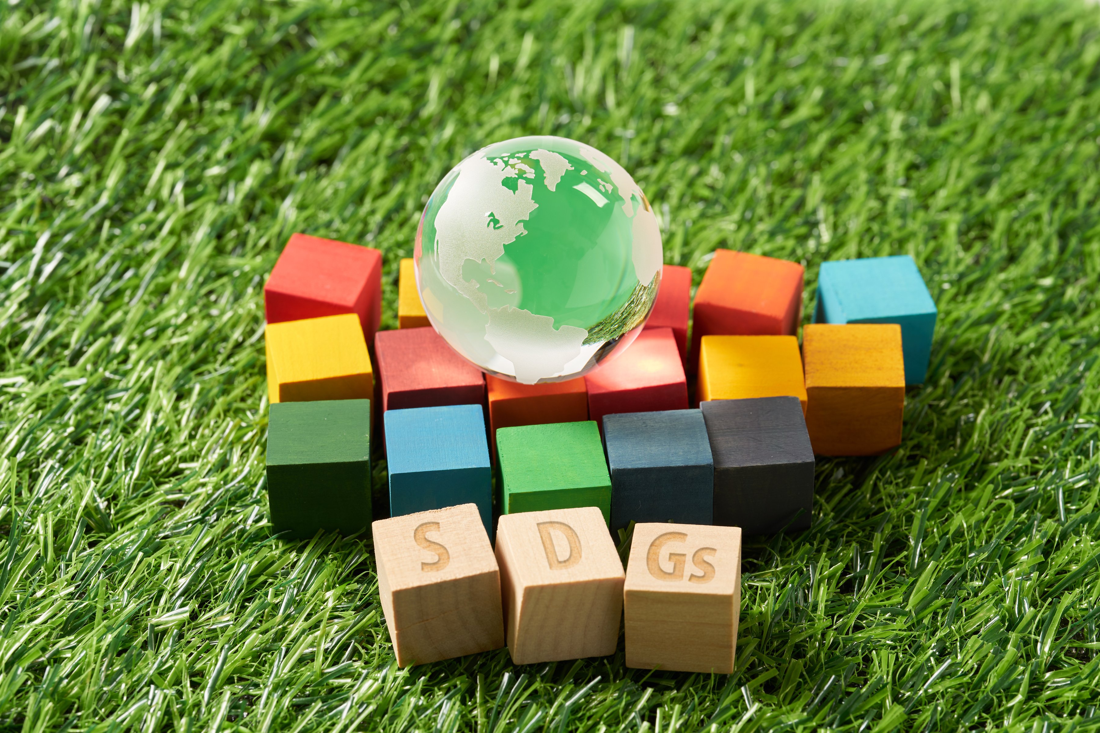 globe and a wooden cube stamped with the letters SDGs.